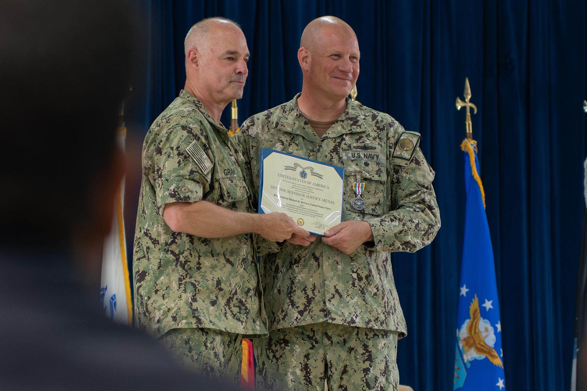 Presiding officer, Rear Adm. Scott Gray presents Devore with the Defense Superior Service Medal. Photo by Skyler Obispo 